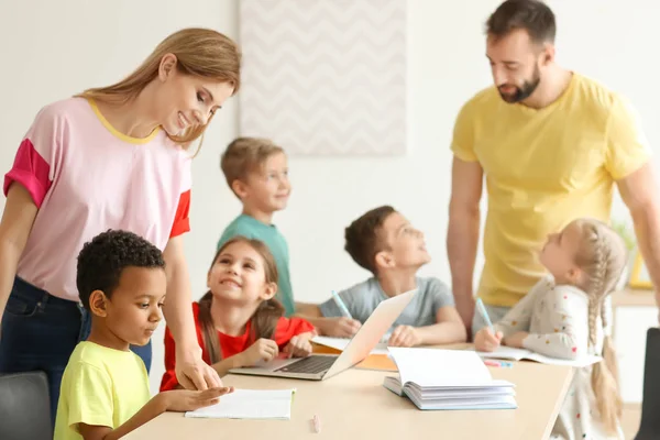 Pomoc dzieciom w odrabianiu prac domowych w klasie w szkole nauczyciele — Zdjęcie stockowe