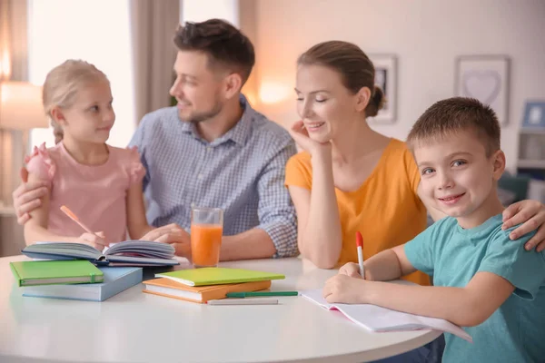 Маленькие дети с родителями делают домашнее задание дома Лицензионные Стоковые Изображения