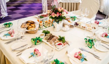 Güzel düğün bulanıklık, seçici odak akşam yemeği masada cam vazoda krem ve pembe gül buketi. Bir lüks düğün tablo ayarı. Masaya çiçek