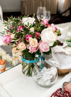 Güzel düğün yemek masası, seçici odak üzerinde cam vazoda krem ve pembe gül buketi. Bir lüks düğün tablo ayarı. Masaya çiçek
