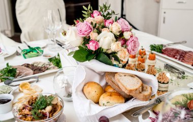 Güzel düğün yemek masası, seçici odak üzerinde cam vazoda krem ve pembe gül buketi. Bir lüks düğün tablo ayarı. Masaya çiçek