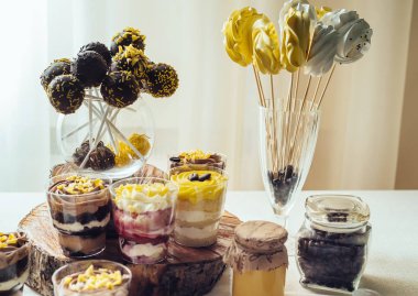 Meringues kahve çekirdekleri ile cam çubuk üzerinde. Tatil çikolata kahverengi ve sarı renkte. Çikolatalı kek Çikolata düğün çıkar, düğün çikolata, seçici odak üzerinde bardaklarda tatlılar