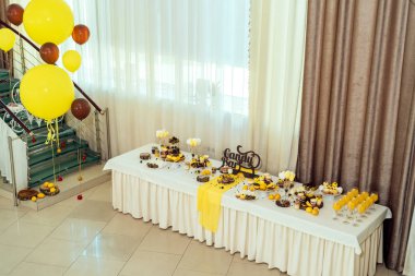 Tatil çikolata kahverengi ve sarı renkte. Çikolata ile cupcakes hizmet düğün, pasta çıkar, gözlük, limon ve kahve çekirdekleri tatlılar 