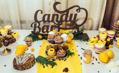 Tatil çikolata kahverengi ve sarı renkte. Çikolata ile cupcakes hizmet düğün, pasta çıkar, gözlük, limon ve kahve çekirdekleri tatlılar 