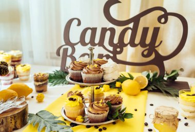 Tatil çikolata kahverengi ve sarı renkte. Çikolata ile cupcakes hizmet düğün, pasta çıkar, gözlük, limon ve kahve çekirdekleri tatlılar 