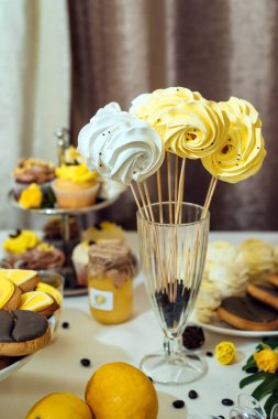 Beyaz ve sarı meringues kahve çekirdekleri ile cam çubuk üzerinde. Tatil çikolata kahverengi ve sarı renkte. Düğün çikolata 
