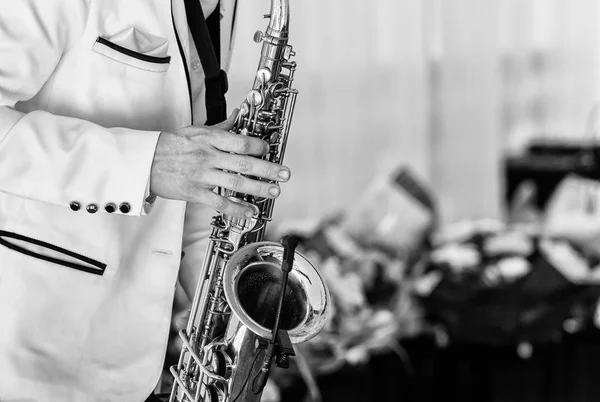 Beyaz ceketli saksafoncu saksafon çalıyor. Düğünde saksafoncu cazcı ve saksafoncu.