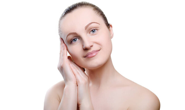 Portrait of a girl with nude make-up with hands near her face isolated on white background. Girl with clean healthy skin on white. Cosmetology, spa, medicine, beauty care. Beauty model. Nude makeup