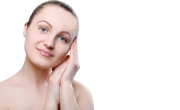 Portrait of a girl with nude make-up with hands near her face isolated on white background. Girl with clean healthy skin on white. Copy space. Beauty model