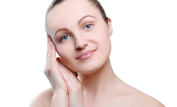 Portrait of a girl with nude make-up with hands near her face isolated on white background. Girl with clean healthy skin on white. Cosmetology, spa, medicine, beauty care. Beauty model. Nude makeup