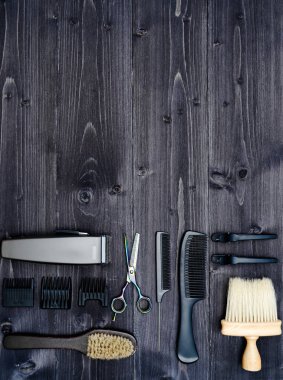 Kuaför araçlar ahşap arka plan üzerinde. Üstten görünüm makas, tarak, fırçaları ve tokalar, boş alan ahşap tablo. Berber dükkanı