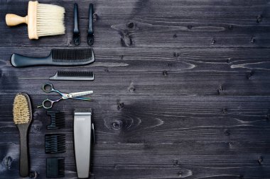 Kuaför araçlar ahşap arka plan üzerinde. Üstten görünüm makas, tarak, fırçaları ve tokalar, boş alan ahşap tablo. Berber dükkanı