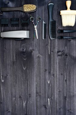 Kuaför araçlar ahşap arka plan üzerinde. Üstten görünüm makas, tarak, fırçaları ve tokalar, boş alan ahşap tablo. Berber dükkanı