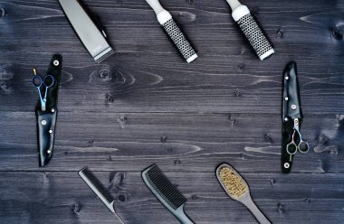 Kuaför araçlar ahşap arka plan üzerinde. Üstten görünüm makas, tarak, fırçaları ve tokalar, boş alan ahşap tablo. Berber, erkeklik kavramı