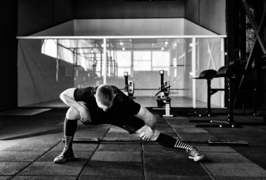 Genç adam eğitim önce kasları hazırlanıyor. Spor salonunda egzersiz kas atlet. Germe adam uygun. Isınma-up profesyonel sporcu. Tam vücut uzunluğu portre