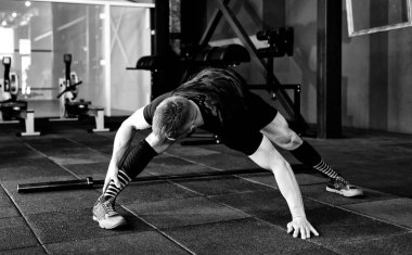 Genç adam eğitim önce kasları hazırlanıyor. Egzersiz kas atlet. Germe adam uygun. Isınma-up profesyonel sporcu