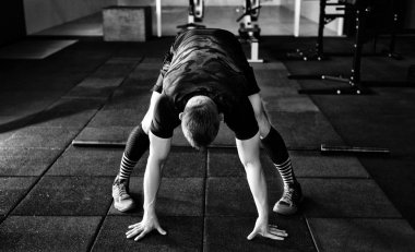 Genç adam eğitim önce kasları hazırlanıyor. CrossFit egzersiz kas atlet. Germe adam uygun. Isınma-up profesyonel sporcu. Egzersiz yaşam tarzı kavramı. 