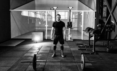 Sakallı adam bir halter salonunda eğitimle hazırlanılıyor