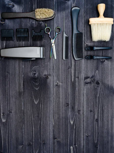 Hairdresser tools on wooden background. Top view on wooden table with scissors, comb, hairbrushes and hairclips, free space. Barbershop