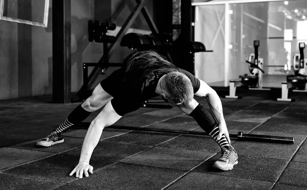 Genç adam eğitim önce kasları hazırlanıyor. Egzersiz kas atlet. Germe adam uygun. Isınma-up profesyonel sporcu