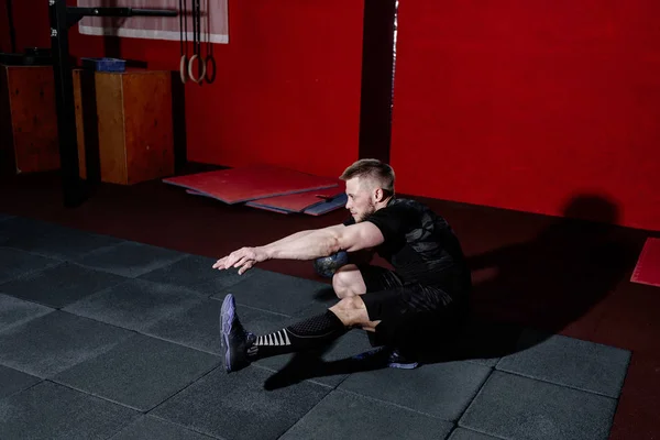 Muscular bearded man doing pistol squats on one leg in gym, copy space