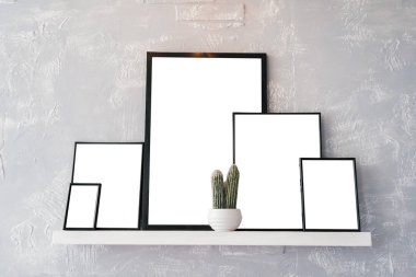 Boş boş beyaz kart ile yer ahşap fotoğraf çerçeveleri içindeki metin için. Beyaz pot gri arka plan üzerinde beyaz raf kaktüs ve fotoğraf çerçeveleri ile. Blog, Web sitesi, sosyal medya kavramı, boş alan