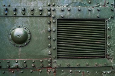 Cıvata ve perçinli yeşil endüstriyel metal arka plan dokusu. Eski boyanmış metal arka plan, askeri uçağın detayları, yüzeyde aşınma, perçinli metal doku.