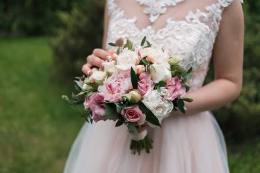 Beyaz ve pembe peonies, gül ve gelinin elinde yeşil yemyeşil düğün buket. Gelin düğün buketi ile 