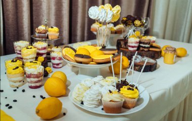 Tatil çikolata kahverengi ve sarı renkte. Çikolata ile cupcakes hizmet düğün, pasta çıkar, gözlük, limon ve kahve çekirdekleri tatlılar 