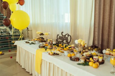 Tatil çikolata kahverengi ve sarı renkte. Çikolata ile cupcakes hizmet düğün, pasta çıkar, gözlük, limon ve kahve çekirdekleri tatlılar 