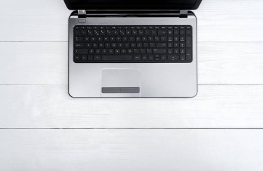 Ahşap beyaz ofis resepsiyon masası ile açık boş dizüstü bilgisayar, boş alan. Üstten görünüm kopya alanı ile. Ahşap arka plan gri laptop