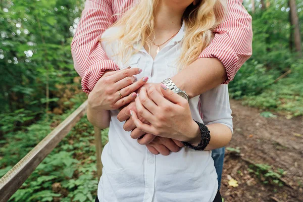 愛のカップルの手 男と女が立っている受け入れ 手を繋いでいます 男性は白いシャツに女性を抱っこ — ストック写真