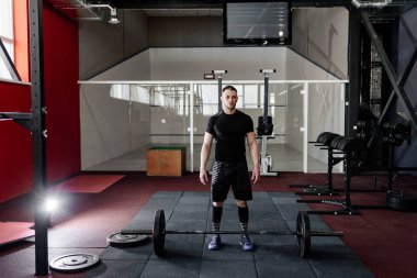 Sakallı adam halter salonunda eğitimle hazırlanılıyor. Tam vücut uzunluğu portre