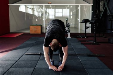 Genç adam eğitim önce kasları hazırlanıyor. Egzersiz kas atlet. Germe adam uygun. Isınma-up profesyonel sporcu