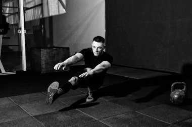 Spor salonunda bir bacak üzerinde tabanca yapan kas sakallı erkek ağız kavgası