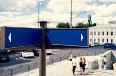 Arka plan, metin için boş alan üzerinde boş mavi sokak işaretleri ile şehir ve insanlar bulanıklık. Boş mavi trafik yol işaretleri parlak gökyüzü bulutlu, metin için özgür yer. Bulutlu gökyüzü arka plan, kopya alanı üzerinde boş sokak tabelası