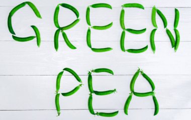 Düz beyaz arka plan, boş alan, gıda arka plan üstten görünüm bakla taze yeşil bezelye yatıyordu