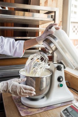 Genç kadın nands için tatlı pasta Hamur hazırlama mutfak Mikser kullanarak lastik eldiven, yakın çekim 