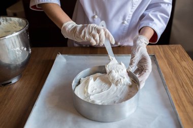 Lastik eldiven vanilyalı kek hamuru kek pişirme için formu hamur hazırlama kadın şef aşçı. Genç kadın baker yemek pişirme içinde hamur dökme