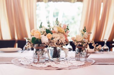 Düğün Buketler sarı, beyaz ve pembe güller vazo yemek masası üzerinde bulunmaktadır