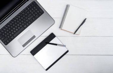 Üstten görünüm açık boş dizüstü bilgisayar, boş günlüğü ve grafik tablet, boş alan beyaz ahşap tablo