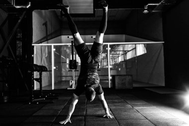 Atlet spor salonunda baş aşağı duran ellerinin üstünde yürümek. Gönderme yapan erkek ups ellerinde. Egzersiz yaşam tarzı kavramı. Tam vücut uzunluğu portre