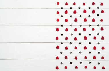 Üstten görünüm olan tatlı taze organik ahududu ve böğürtlen, boş satır. Beyaz ahşap arka plan boşluk ile taze çilek. Yaz ve sağlıklı gıda kavramı düz