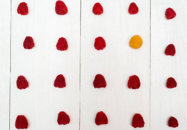 Üstten görünüm olan tatlı taze organik ahududu ve bir sarı ahududu, boş alan satır. Beyaz ahşap arka plan boşluk ile taze çilek. Yaz ve sağlıklı gıda kavramı düz