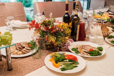 Akşam yemeği tablosunda güzel buket bulanıklık. Lüks düğün tablo ayarı. Masaya çiçek