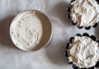 Kek pişirme parşömen kağıt tepsisiyle üzerinde hamur ile pişirme için formları. Ev yapımı kekler masanın üzerine metal yemeklerinde hamur