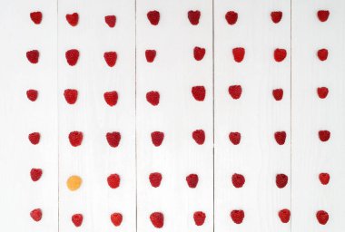 Üstten görünüm kırmızı taze ahududu ve onları boş alan arasında bir sarı ahududu. Yaz, sağlıklı gıda kavramı, düz yatıyordu. Bireysellik, üstün, benzersiz, bağımsızlık, farklı düşünüyorum