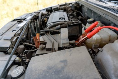 Araba pil şarj kablonuz. Kırmızı ve siyah araba pil booster kabloları. Araba aküsü ile bakır kelepçeler elektrik yalak bağlantı kablosu ile şarj; kopya alanı. Yolda şarj pil