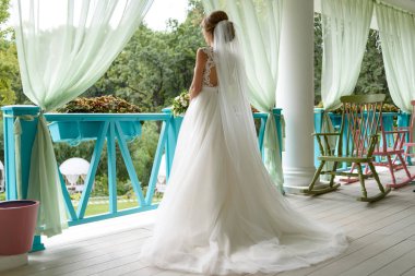 Güzel genç uzun beyaz gelinlik ve sundurma açık havada peçe ayakta gelinle damat düğün töreni önce bekleyen arkadan görünüm, boş alan. Gelin sabah