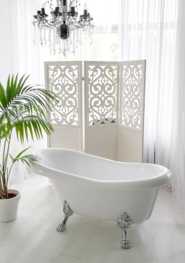 Güzel lüks banyo iç boş alan büyük penceresinde yakınındaki vintage boş küvet. Katlama perde ve palmiye ağacı, kopya alanı yakınında duran beyaz banyo 